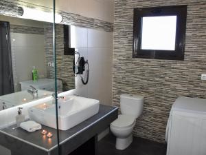a bathroom with a sink and a toilet and a mirror at Madares Apartments Anopolis in Anopoli Sfakion +49 photos