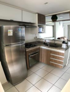 une cuisine avec un réfrigérateur et des armoires en acier inoxydable dans l'établissement APART HOTEL BEACH CLASS FORTALEZA!, à Fortaleza