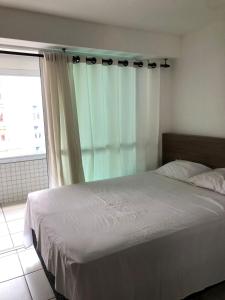 une chambre avec un grand lit avec une fenêtre dans l'établissement APART HOTEL BEACH CLASS FORTALEZA!, à Fortaleza