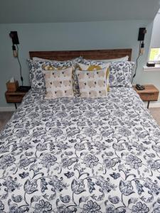 a bed with a black and white comforter and pillows at Barra's Loft in Fort William