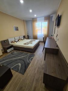 a bedroom with a large bed and a table at Семеен хотел Аристо in Dryanovo