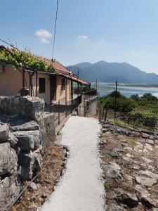 un camino junto a una casa con vistas al agua en The Island of Prevlaka, en Prevlaka