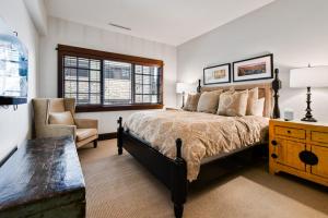 a bedroom with a large bed and a chair at Arrowleaf Lodge - 3 Bed Condo #302 in Park City