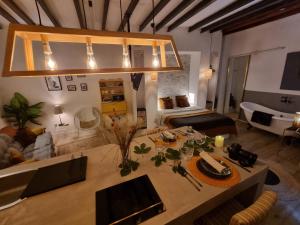 a living room with a table and a room with a bed at Lofts amantes de Toledo -LOFT SAGRARIO in Toledo