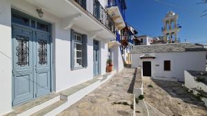 un vicolo con edifici bianchi e una porta blu di Townhouse Christos a Panormos Skopelos