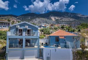 una casa blu con piscina e montagne sullo sfondo di Κefalonia Golden View Villa a Cefalonia