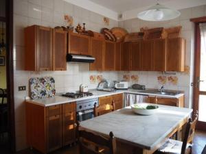 a kitchen with wooden cabinets and a table with a bowl on it at Il Giardino Sul Lago in Viverone