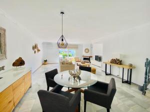 a dining room and living room with a table and chairs at Happy Beach House in Manilva