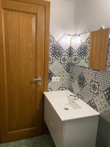 Un baño con lavabo y puerta de madera. en Villino La Funtana, en San Teodoro