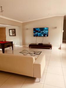 a living room with a couch and a flat screen tv at 6th on Brooke in Johannesburg
