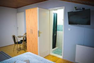 a bedroom with a door and a tv on a wall at Royal TSV Rooms in Sombor