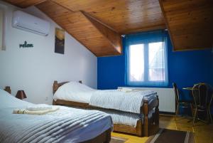 a bedroom with two beds and a blue wall at Royal TSV Rooms in Sombor