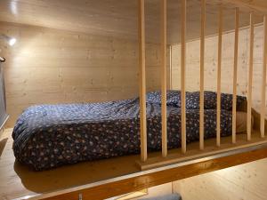 uma cama num quarto de madeira com um berço em TINY HOUSE LA FARIGOULE em Pélissanne