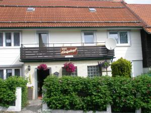 a white house with a balcony and flowers at Harzpension Haus Königskopf in Braunlage