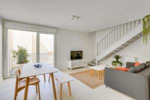 - un salon blanc avec un canapé et une table dans l'établissement "Le Massilia" Beau duplex avec balcon à Marseille, à Marseille
