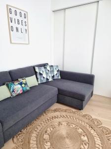 Vera Cruz Suite Apartment في أفيرو: أريكة زرقاء في غرفة المعيشة مع سجادة