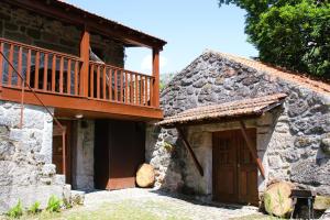 a house with a balcony and a wooden door at Casa Boletus in Castro Laboreiro