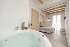 a large white bath tub in a room with a bedroom at Naxos Blue Sky in Naxos Chora
