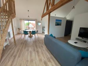 - un salon avec un canapé bleu et une table dans l'établissement Superbe appartement neuf à Barneville Plage, à Barneville-Carteret