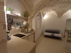 a kitchen with a sink and a couch in a room at Il Campanile in Cisternino