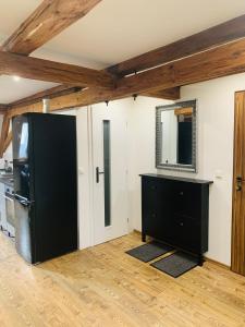 a kitchen with a black refrigerator and a mirror at Boulevard Ferienwohnung in Waldsassen