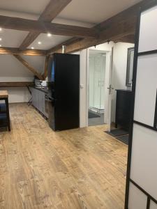 a kitchen with a black refrigerator and a wooden floor at Studio-Apartments Boulevard in Waldsassen