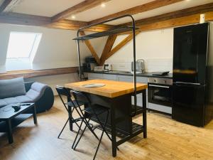 a kitchen with a table and a loft bed in a room at Boulevard Ferienwohnung in Waldsassen