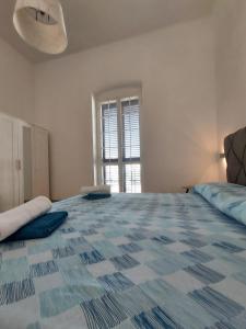 a large white room with a large bed with a window at Dimora Trinity in Polignano a Mare
