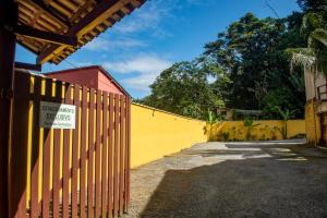 a yellow fence with a sign on it at Pousada Cachadaço in Trindade