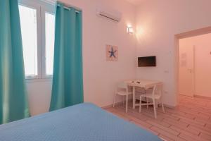 sypialnia ze stołem i pokój z łóżkiem w obiekcie Approdo Rooms - Eja Sardinia w Cagliari
