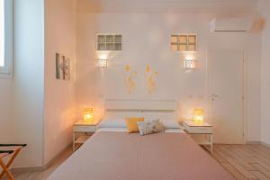 sypialnia z dużym białym łóżkiem z 2 lampami w obiekcie Approdo Rooms - Eja Sardinia w Cagliari