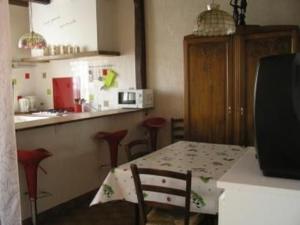 a kitchen with a table and some chairs and a counter at Gîte Champêtre avec Piscine Chauffée, Cheminée, et Terrasse en Plein Sud - FR-1-410-131 in La Chapelle-aux-Choux +6 photos