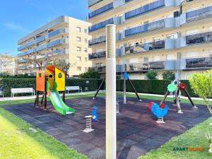 een speeltuin in een park naast een gebouw bij APARTBEACH NOVA PINEDA con PARKING Y CLIMA in La Pineda