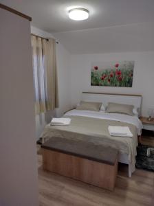 a bedroom with a bed and a painting on the wall at Apartmani Bernarda in Poreč