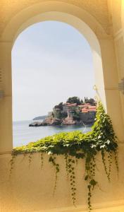 uma janela com vista para o oceano e uma ilha em Sound of the Sea Apartment na Ilha Sveti Stefan