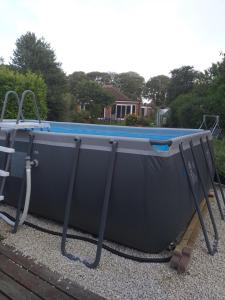 a large pool sitting on top of a yard at Delightful cosy cabin in Margate