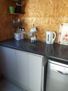 a kitchen counter with a black counter top at Delightful cosy cabin in Margate