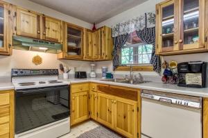 a kitchen with wooden cabinets and a sink at Laurel Cottage, 560 FREE tickets each paid day, Hot Tub, Pool Table! in Sevierville