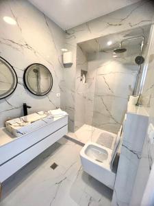La salle de bains blanche est pourvue d'un lavabo et de toilettes. dans l'établissement Durres Currila Modern Luxury STUNNING Beach Views, à Durrës