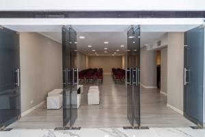 a conference room with glass doors and red chairs at Loft Argentino Apart Buenos Aires in Buenos Aires