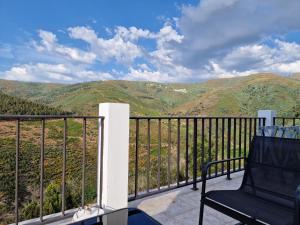 a balcony with a chair and a view of mountains at D'aqui e D'acolá - Pardieiros in Pardieiros