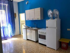 a kitchen with blue walls and a white refrigerator at Home Willy in Florence