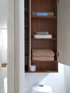La salle de bains est pourvue d'une armoire avec des serviettes et des toilettes. dans l'établissement Cálido apartaestudio en La Castellana, à Armenia