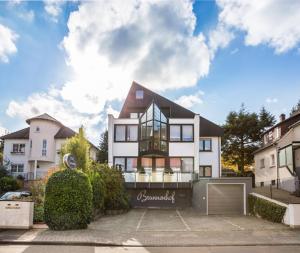a large white house with a gate in front of it at Hotel Brunnenhof in Hanau am Main