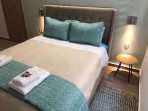 - une chambre avec un grand lit et des oreillers verts dans l'établissement Royal Blue Grand Suite No 2, au Pirée