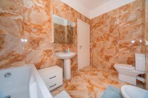 um banheiro com uma pia, um vaso sanitário e uma banheira em Alex Lux sea view aparmtent 2 em Rafailovici