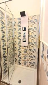 a shower with a glass enclosure with fishes on the wall at B&B Giostell in Marina di Camerota