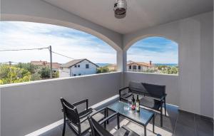 un balcone con tavolo, sedie e 2 finestre di 4 Bedroom Stunning Home In Privlaka a Privlaka (Brevilacqua)