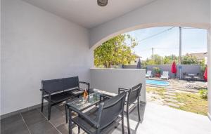 um pátio com uma mesa e cadeiras e uma piscina em 4 Bedroom Stunning Home In Privlaka em Privlaka