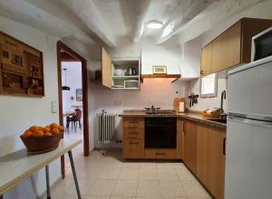 a kitchen with a table with a bowl of oranges on it at LA MUNTANYA - Apartamentos Rural Guadalest in Benimantell